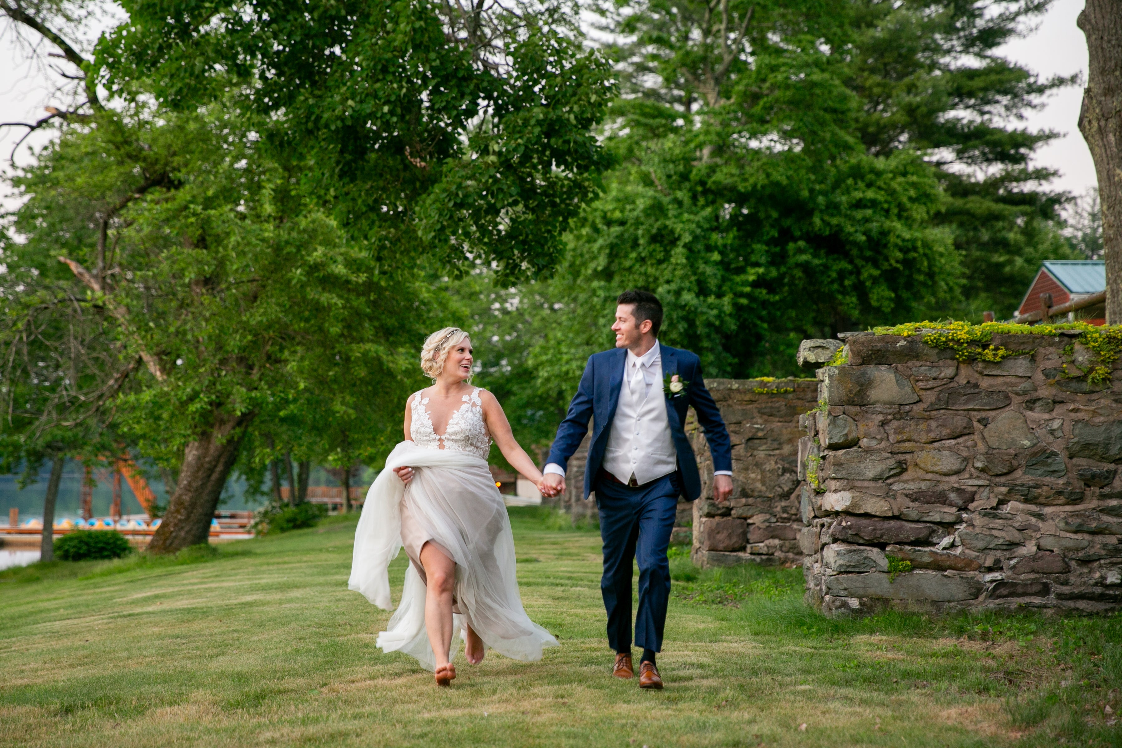 Bride and Groom Running in green grass field at Trout Lake 